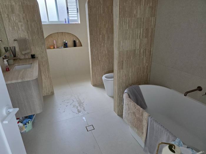 Bathroom renovation with freestanding bath and stone-tiled walls