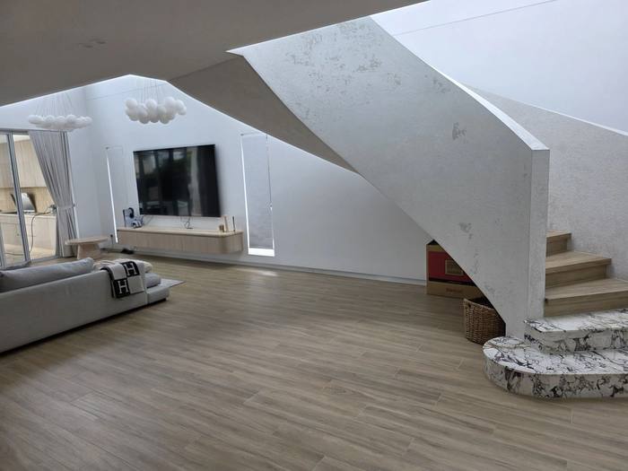 Open-plan living area with staircase and marble feature base